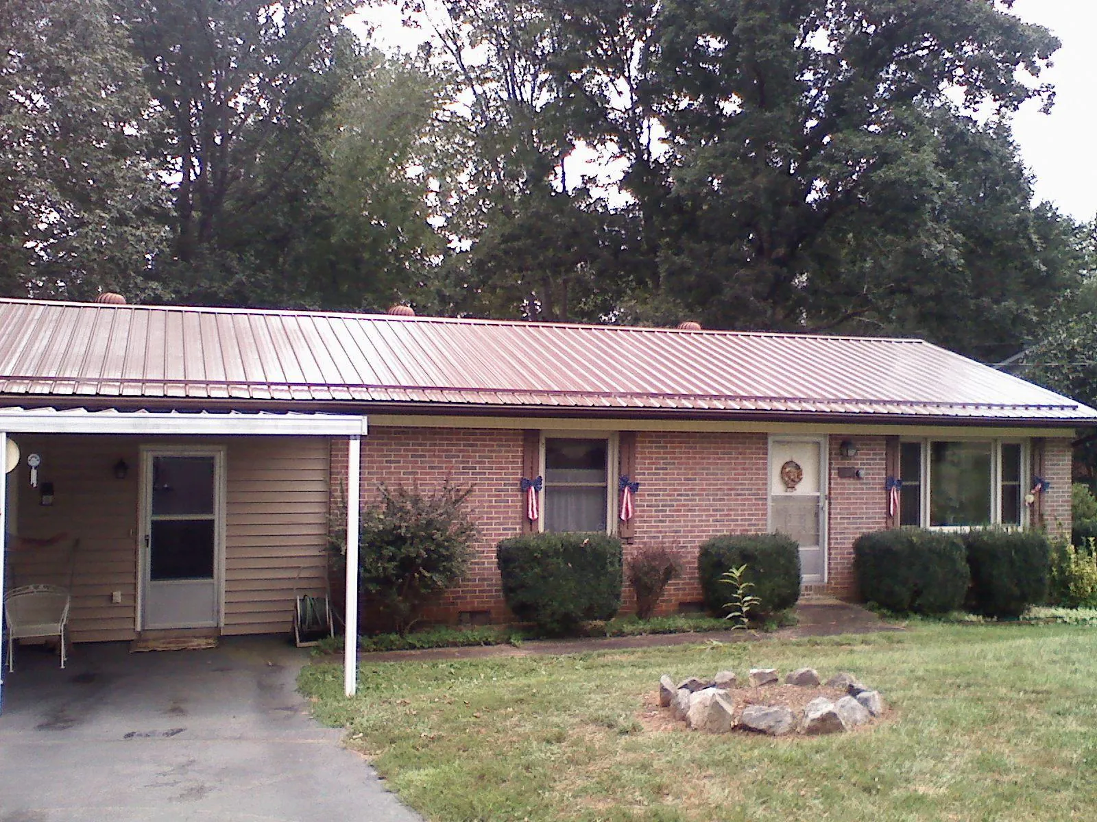 Bronze metal roof and carport on a brick ranch home — Roof Repair work by our crew in Sapphire